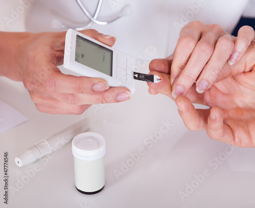 Photo: Doctor testing a patients glucose level Doctor testing a patients glucose level
