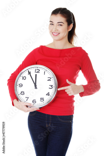 Photo: Happy young woman holding office clock Happy young woman holding office clock