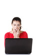 Surprised and disgusted woman working on laptop.