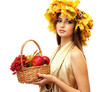 beautiful woman with wreath and basket with apples and berries,