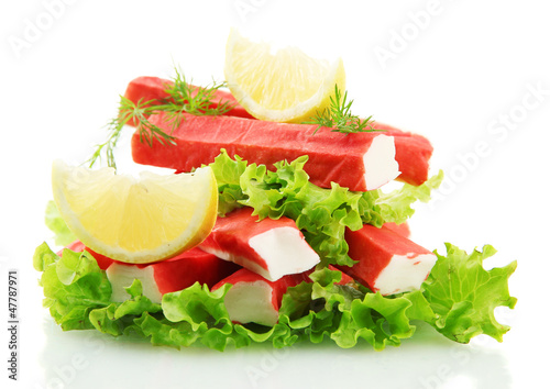 Photo: Crab sticks on lettuce leaves with lemon, isolated on white Crab sticks on lettuce leaves with lemon, isolated on white