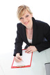 Businesswoman writing on a clipboard