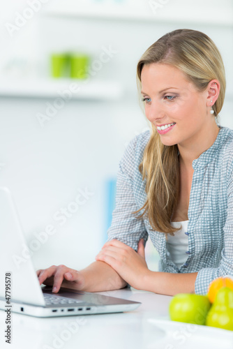 Photo: junge frau schaut auf ihr notebook junge frau schaut auf ihr notebook