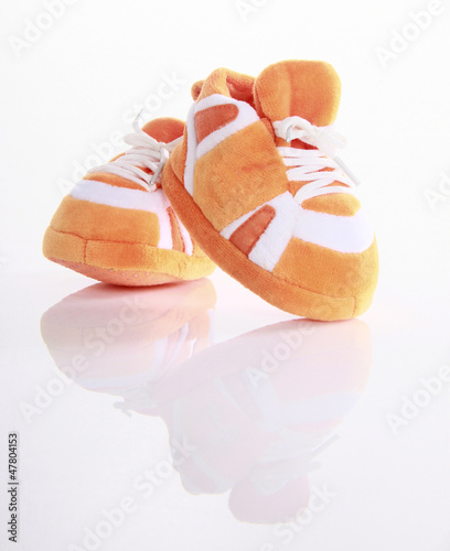 Photo: Orange baby boots isolated Orange baby boots isolated