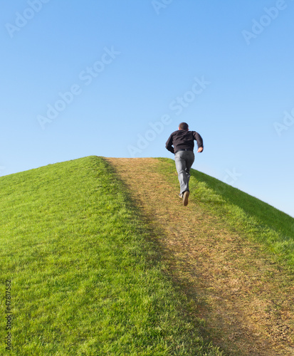 Photo: Pathway up the hill against the sky. Man ran to the top Pathway up the hill against the sky. Man ran to the top