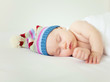 sleeping baby wearing funny striped hat