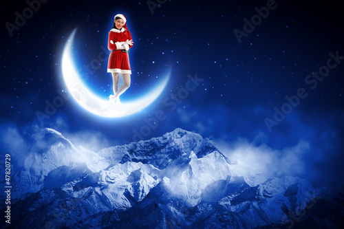 Photo: photo of santa girl sitting on the moon photo of santa girl sitting on the moon