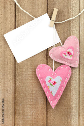 Photo: Two hearts hanging on line with a message attached with a peg Two hearts hanging on line with a message attached with a peg