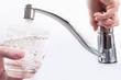 Wasserglas wird am Wasserhahn gefüllt