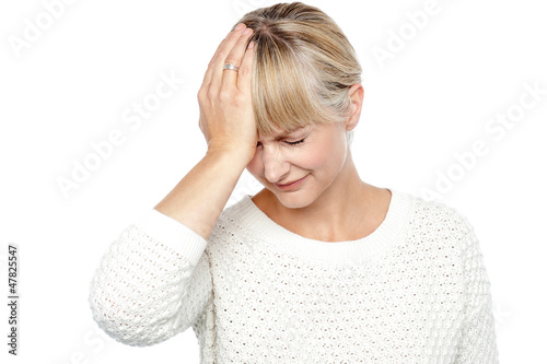 Photo: Sad middle aged woman suffering from headache Sad middle aged woman suffering from headache