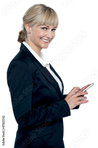Photo: Female executive operating touch screen cellphone Female executive operating touch screen cellphone