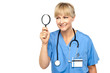 Pretty physician looking through magnifying glass
