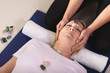 Photo: Young therapist arranging crystals on female client for reiki th Young therapist arranging crystals on female client for reiki th