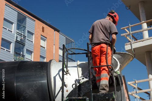 Photo: Concrete mixer truck operator is checking equipments Concrete mixer truck operator is checking equipments