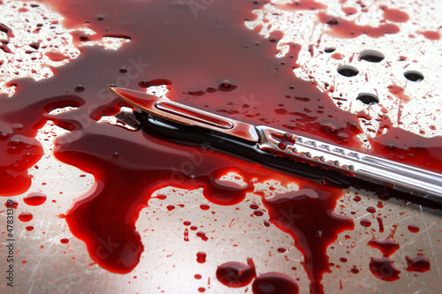 Photo: Surgeon knife on stainelss steel autopsy table Surgeon knife on stainelss steel autopsy table