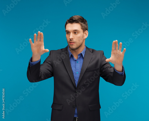 Photo: man in suit working with something imaginary man in suit working with something imaginary