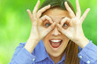 smiling teenage girl shows glasses out of fingers