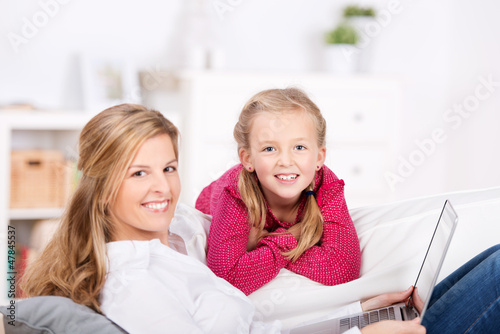 Photo: mutter und tochter mit laptop auf dem sofa mutter und tochter mit laptop auf dem sofa