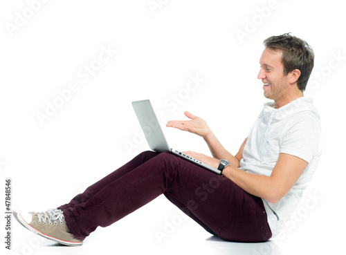 Photo: junger mann schaut lachend auf sein laptop junger mann schaut lachend auf sein laptop