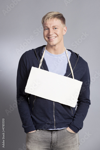 Photo: Smiling friendly man holding blank signboard. Smiling friendly man holding blank signboard.