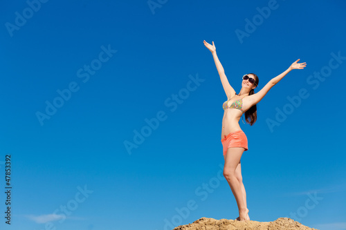 Photo: Portrait of young woman in bikini at beach Portrait of young woman in bikini at beach