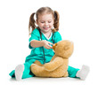 Adorable child with clothes of doctor and teddy bear over white