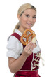 junge frau im dirndl mit brezel