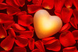 Glowing heart amongst red rose petals