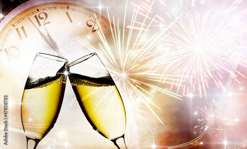 Photo: champagne glasses against clock and fireworks champagne glasses against clock and fireworks