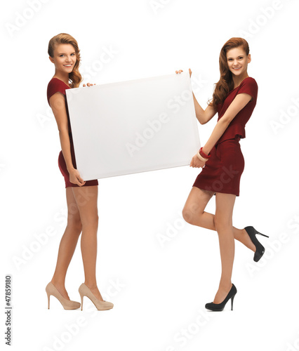 Photo: two teenage girls in red dresses with blank board two teenage girls in red dresses with blank board