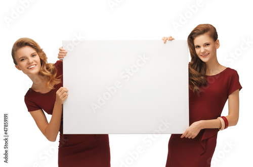 Photo: two teenage girls in red dresses with blank board two teenage girls in red dresses with blank board