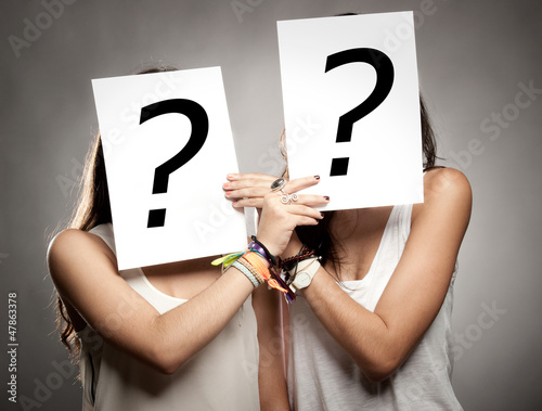 Photo: young women with interrogation symbols young women with interrogation symbols