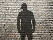 ombre de jeune à casquette sur vieux mur