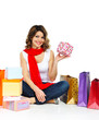 Photo: Young girl in red scarf sitting with shopping bags isolated on w Young girl in red scarf sitting with shopping bags isolated on w