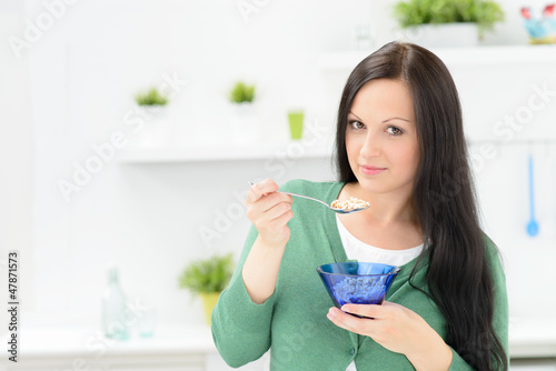 Photo: junge frau isst flakes zum frühstück junge frau isst flakes zum frühstück