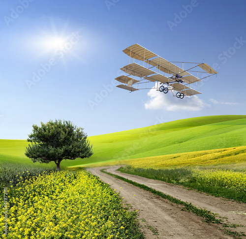 Photo: Vintage aircraft over the green field Vintage aircraft over the green field