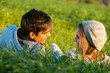 Couple laying in grass field at sunset.