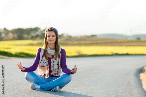 Photo: Young girl meditating outdoors. Young girl meditating outdoors.