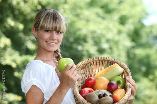 Photo: Woman holding a basket of fruit Woman holding a basket of fruit