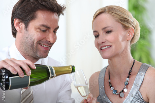 Photo: Man serving cup to blonde woman Man serving cup to blonde woman