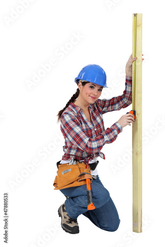 Photo: Woman measuring a piece of wood Woman measuring a piece of wood