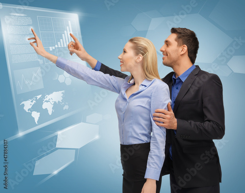 Photo: man and woman working with virtual touch screens man and woman working with virtual touch screens