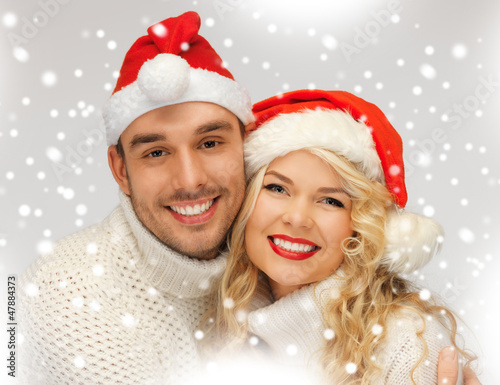 Photo: family couple in sweaters and santa's hats family couple in sweaters and santa's hats