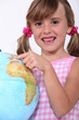 little girl playing with a globe