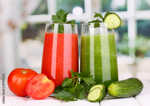 Photo: Fresh vegetable juices on wooden table, on window background Fresh vegetable juices on wooden table, on window background