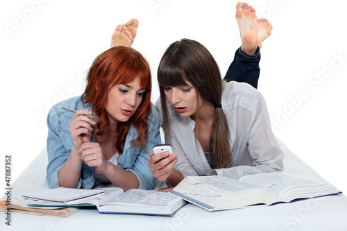 Photo: Two teenage girls studying on the floor Two teenage girls studying on the floor