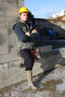 Builder casually leaning against wall
