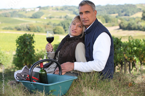 Photo: Couple drinking wine by vineyard Couple drinking wine by vineyard
