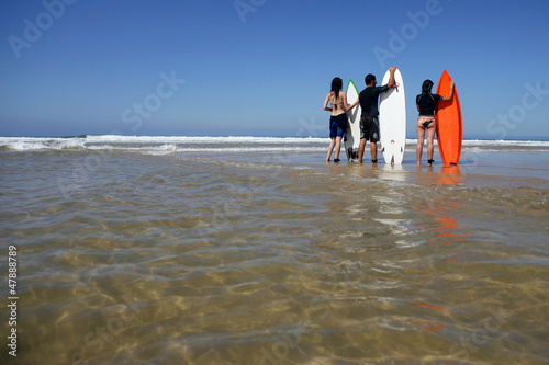 Photo: Three surfers waiting for big wave Three surfers waiting for big wave