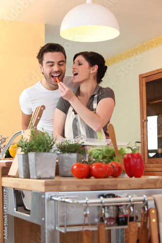 Photo: a woman feeding a carrot to her husband a woman feeding a carrot to her husband